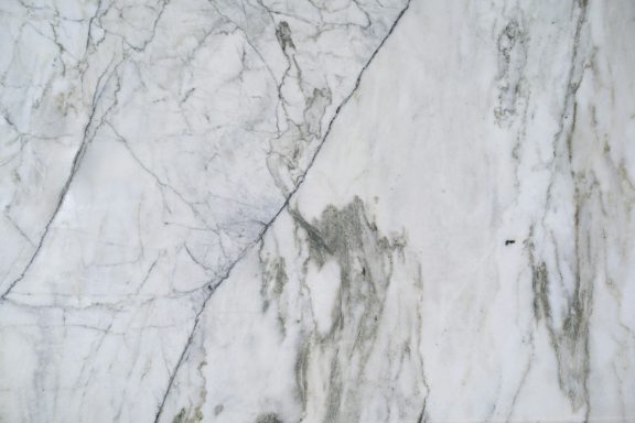 White marble surface with grey and beige veining.